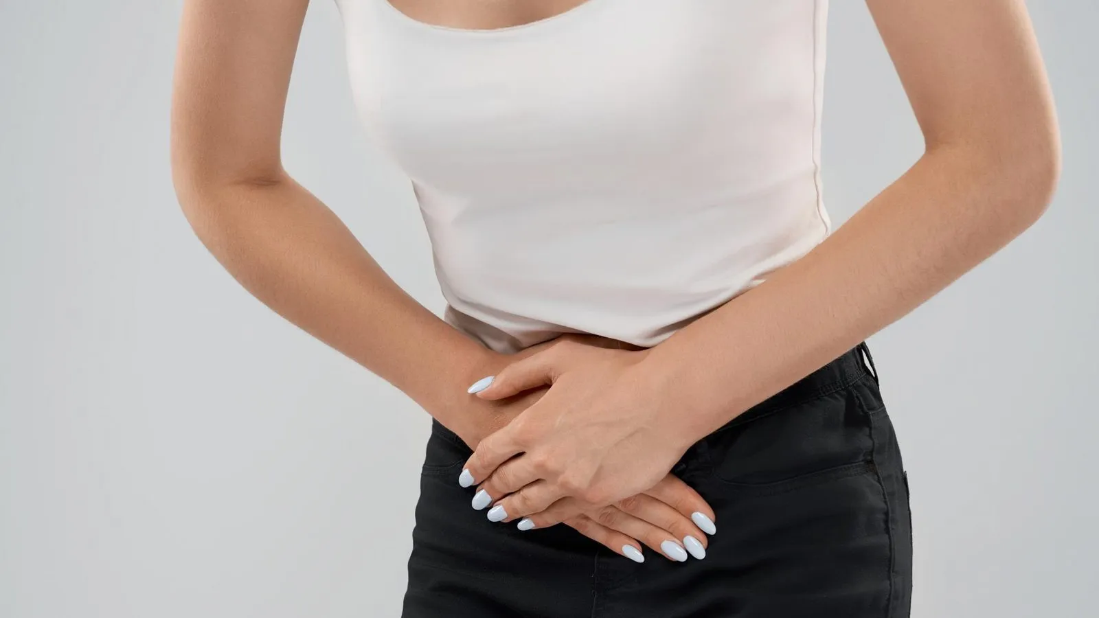 Mujer sentada en un sofá con expresión de molestia abdominal